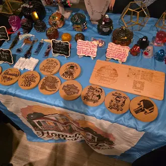 Craft booth display — wood-burned coasters & gifts